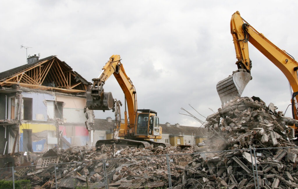A digger demolishing houses for reconstruction.