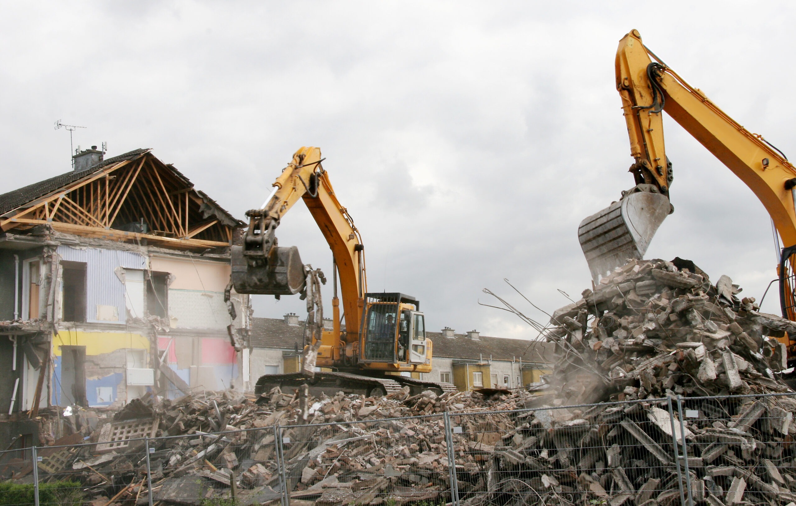 A digger demolishing houses for reconstruction.