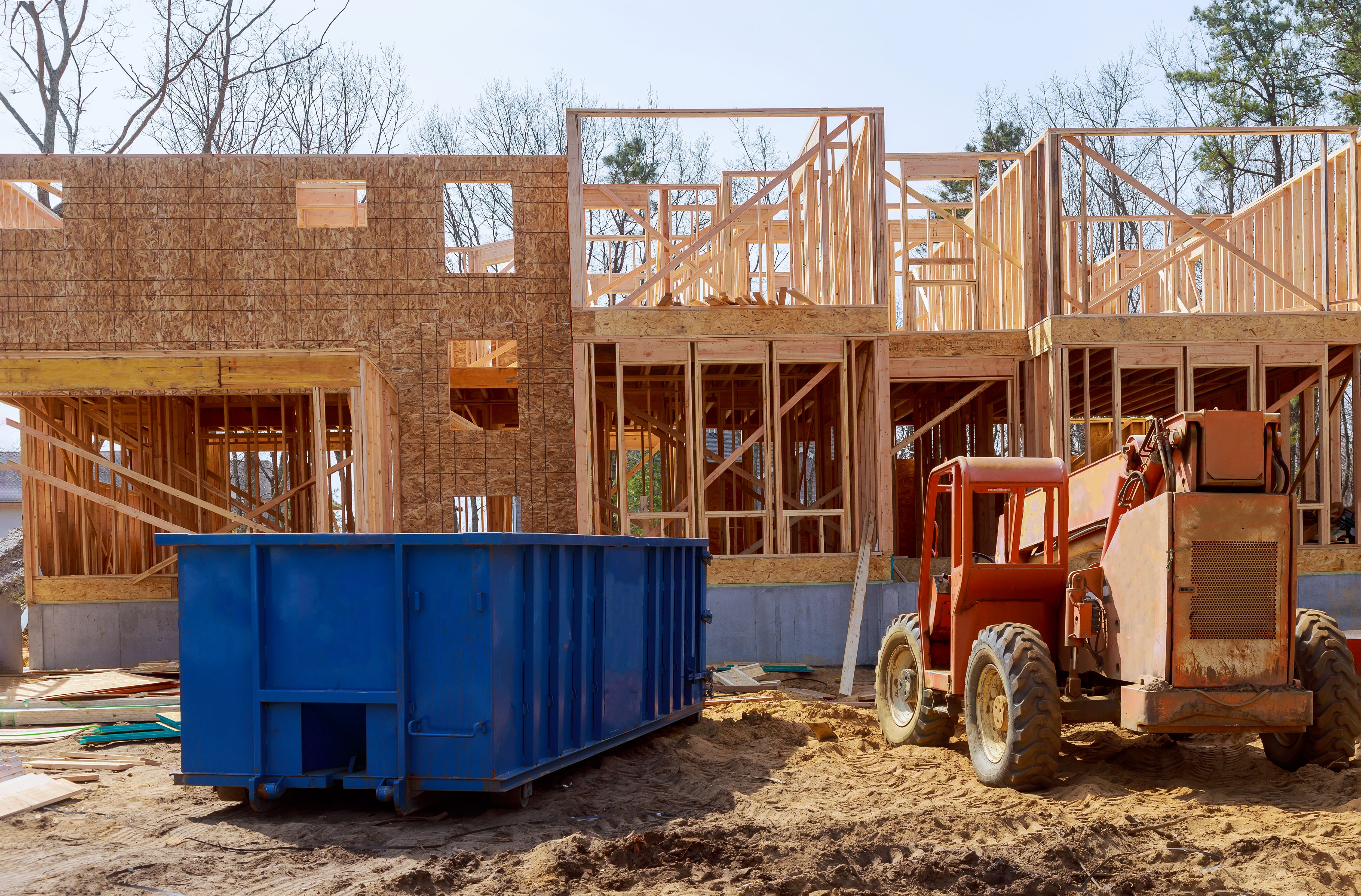 Blu dumpster, recycle waste and garbage bins near new construction site of appartment houses building; Shutterstock ID 1395164630; purchase_order: Limited 10/13/21; job: ; client: ; other: